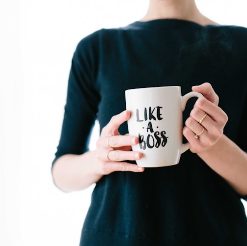 woman holding white mug while standing