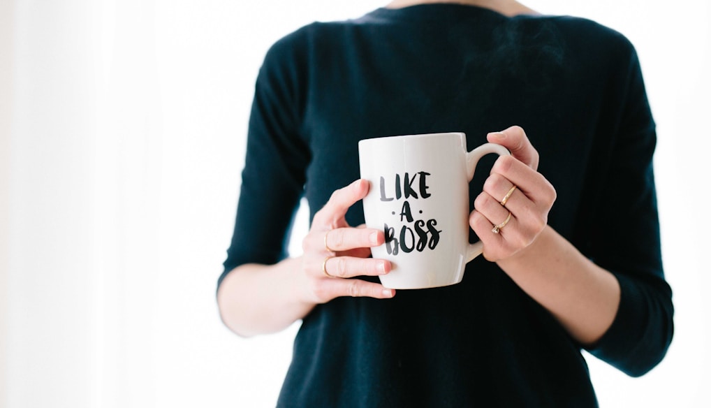 woman holding white mug while standing