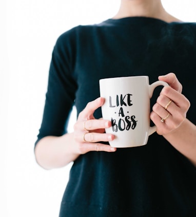 woman holding white mug while standing