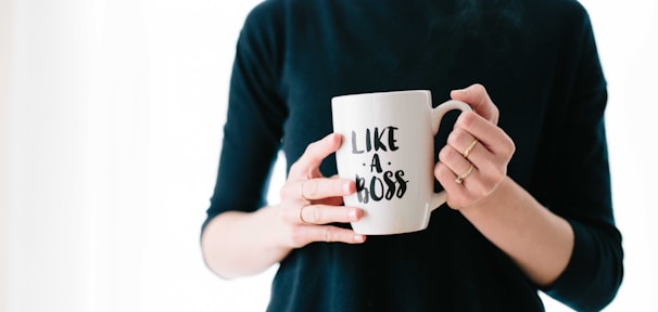 woman holding white mug while standing