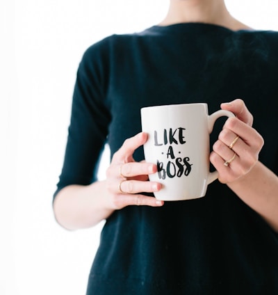 woman holding white mug while standing