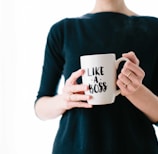 woman holding white mug while standing