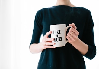 woman holding white mug while standing