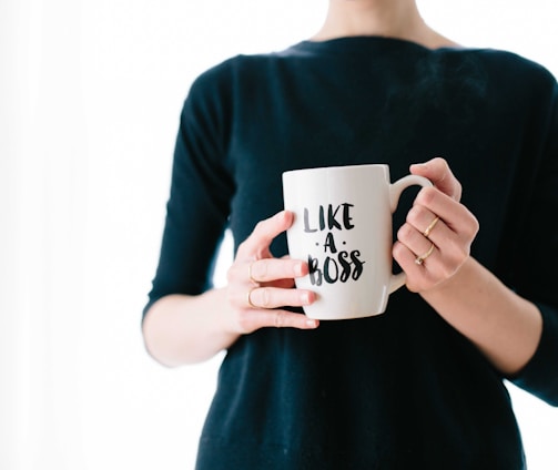 woman holding white mug while standing