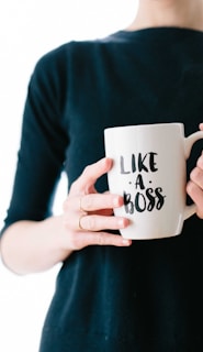 woman holding white mug while standing