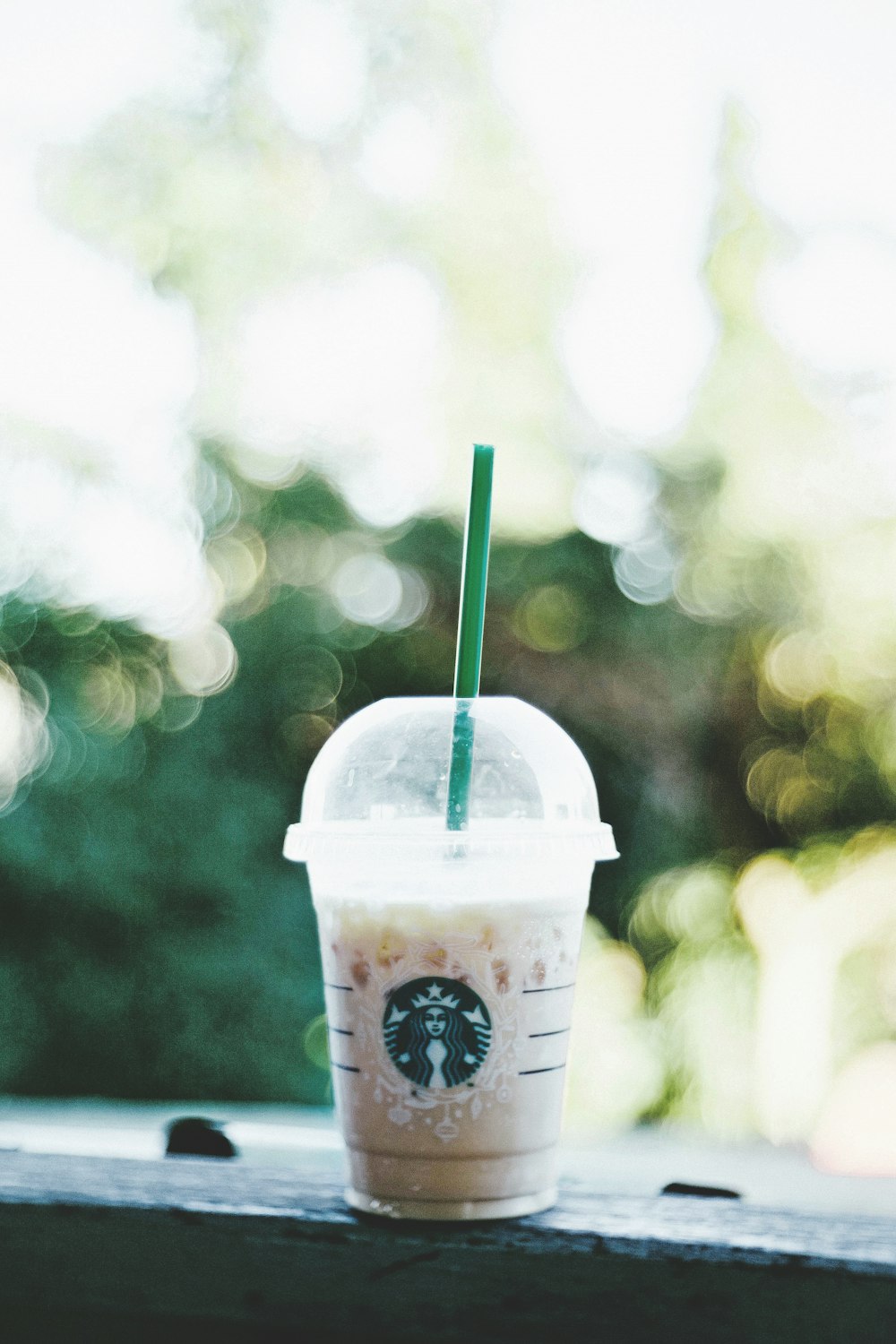 Batido de Starbucks en banco gris fotografía bokeh