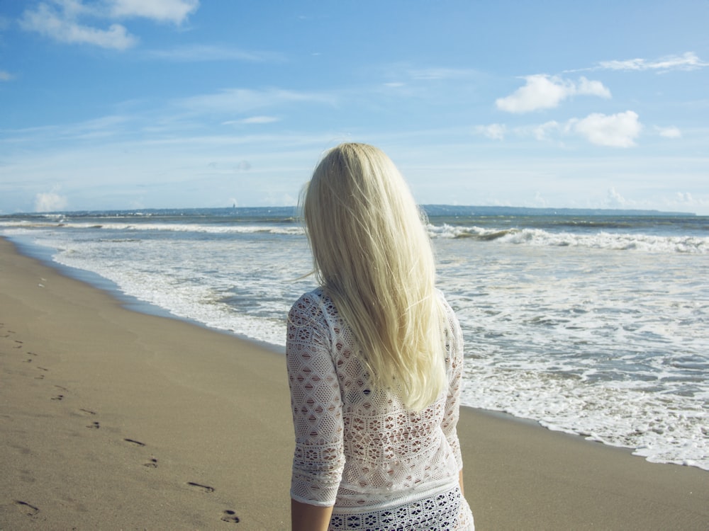 woman walking on shore during day