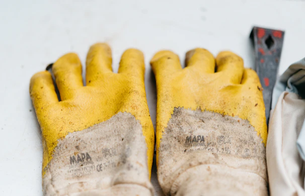 Close-up of a pair of Summitech chemical-resistant gloves displayed on a clean industrial workbench.
