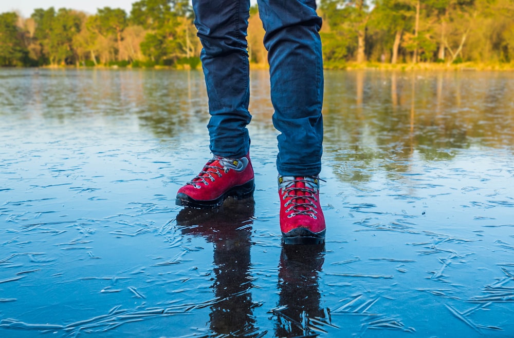 person wearing shoes standing on wet ground