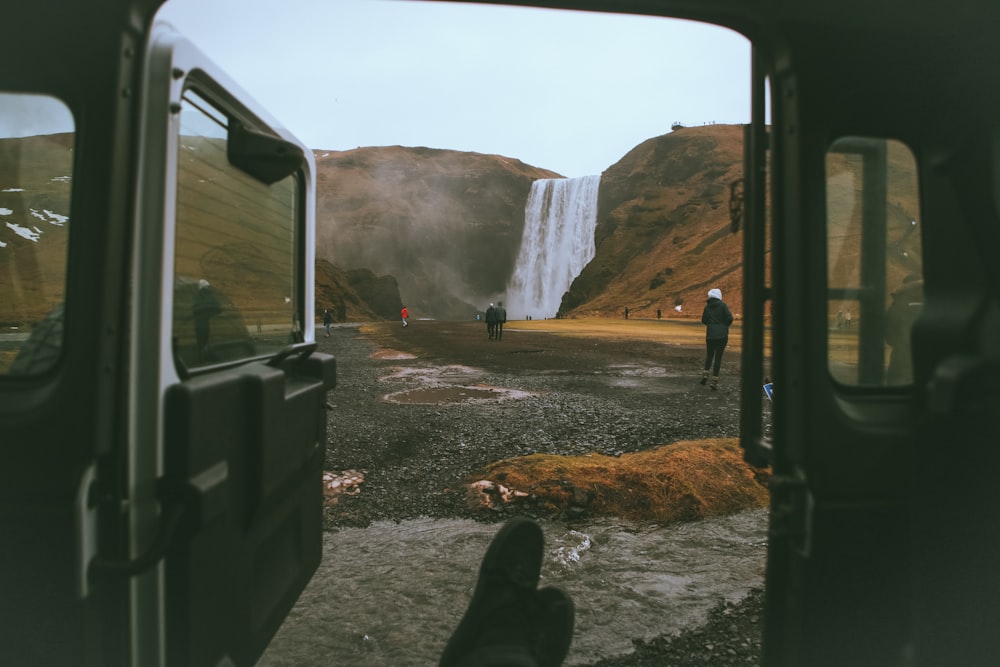 people standing around waterfall