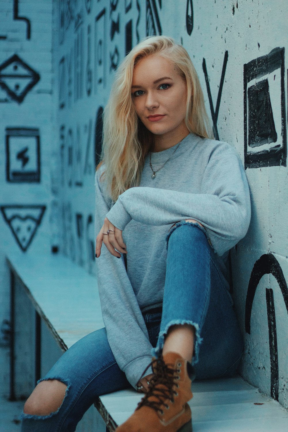 woman sitting beside black and white wall