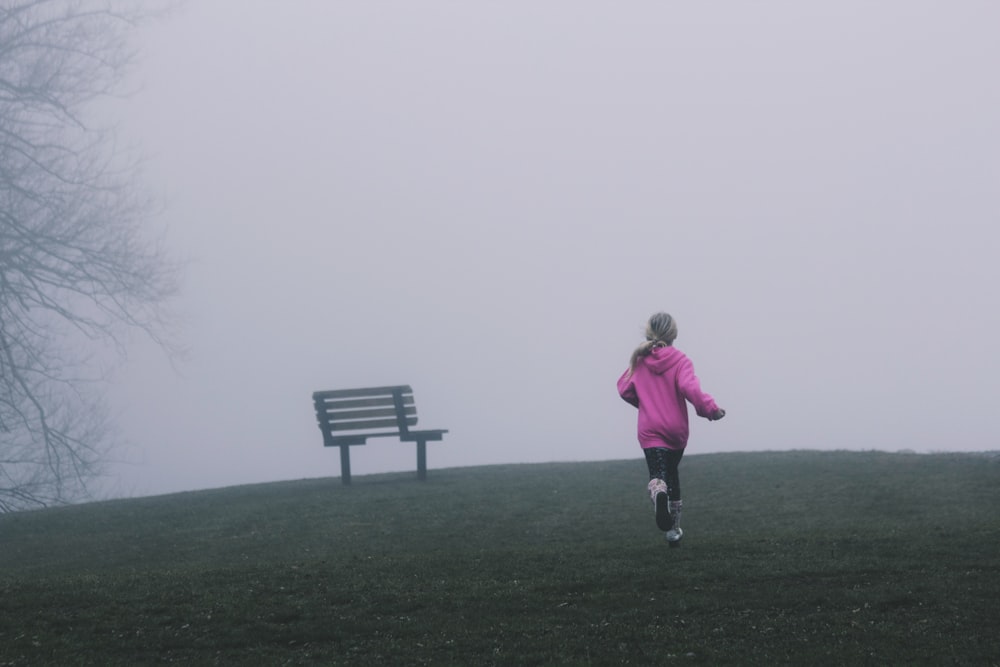 Ragazza che corre vicino alla panchina nera