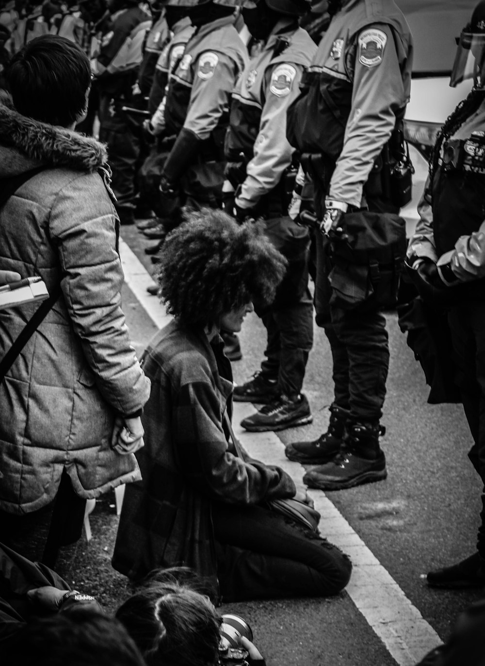 person kneeling before police officers