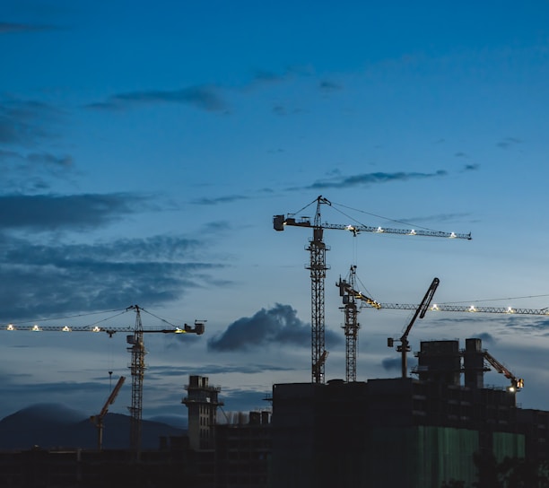 several cranes above the buildings