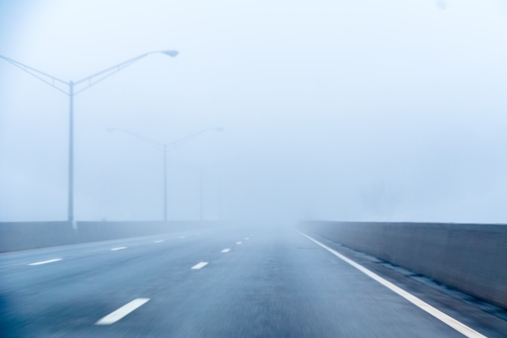 gray concrete road with street lights at daytime