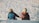 two people sitting on snow during daytime