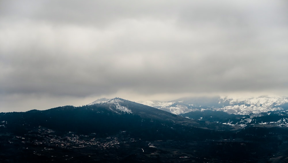 Montaña rocosa negra bajo cielo nublado blanco durante el día
