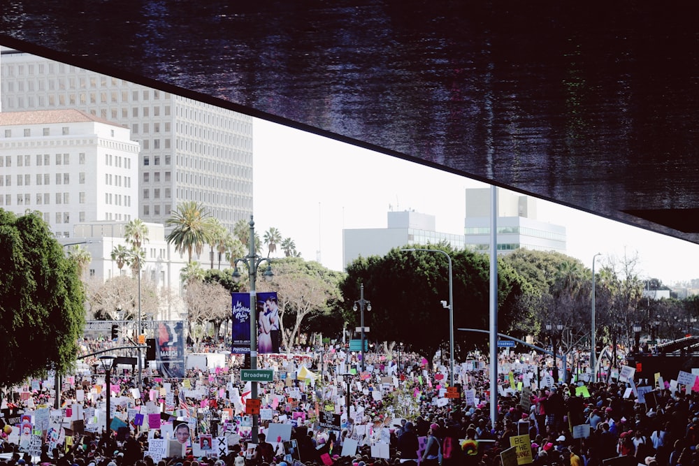 crowd of people near concrete buildings during daytime