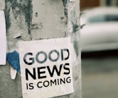 white Good News Is Coming paper on wall