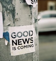 white Good News Is Coming paper on wall