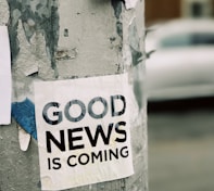 white Good News Is Coming paper on wall