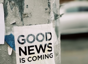 white Good News Is Coming paper on wall