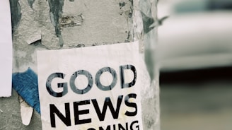 white Good News Is Coming paper on wall