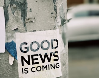 white Good News Is Coming paper on wall