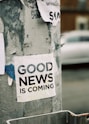 white Good News Is Coming paper on wall