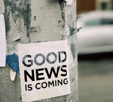 white Good News Is Coming paper on wall