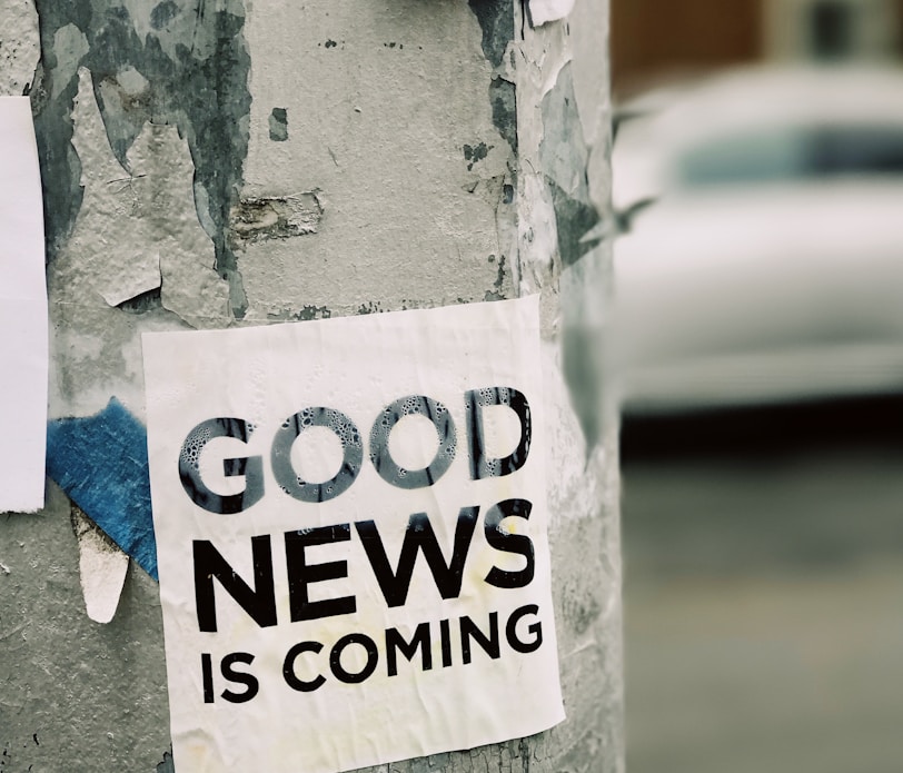 white Good News Is Coming paper on wall