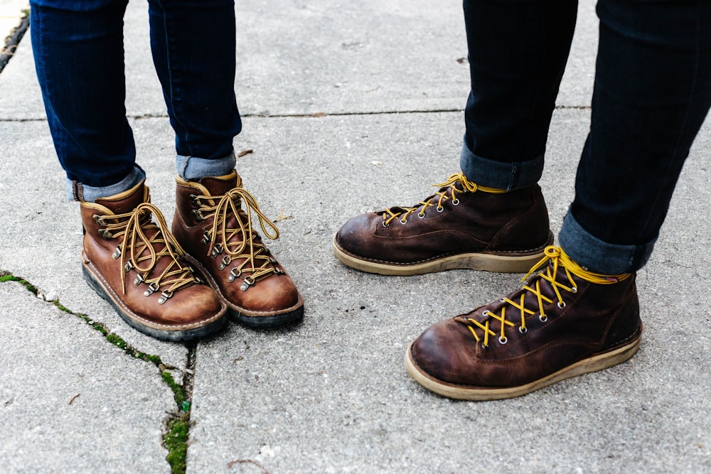 deux personnes portant des bottes en cuir marron