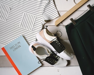 pair of white-and-black low-top sneakers near black skirt on brown clothes hanger top view photography