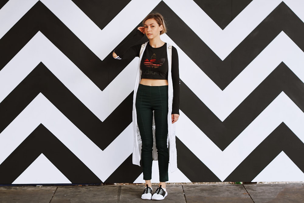 woman standing beside white and black chevron wall