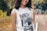 A person wearing a funny t-shirt with a playful design, smiling outdoors.