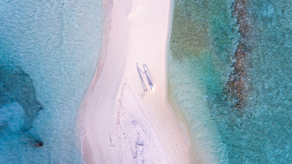 水域の間に立つカップルの航空写真