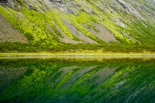 reflection of sloping land on still water in Gryllefjord Norway