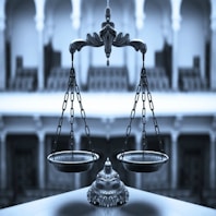 Elegant law books and a golden scale on a black marble desk.