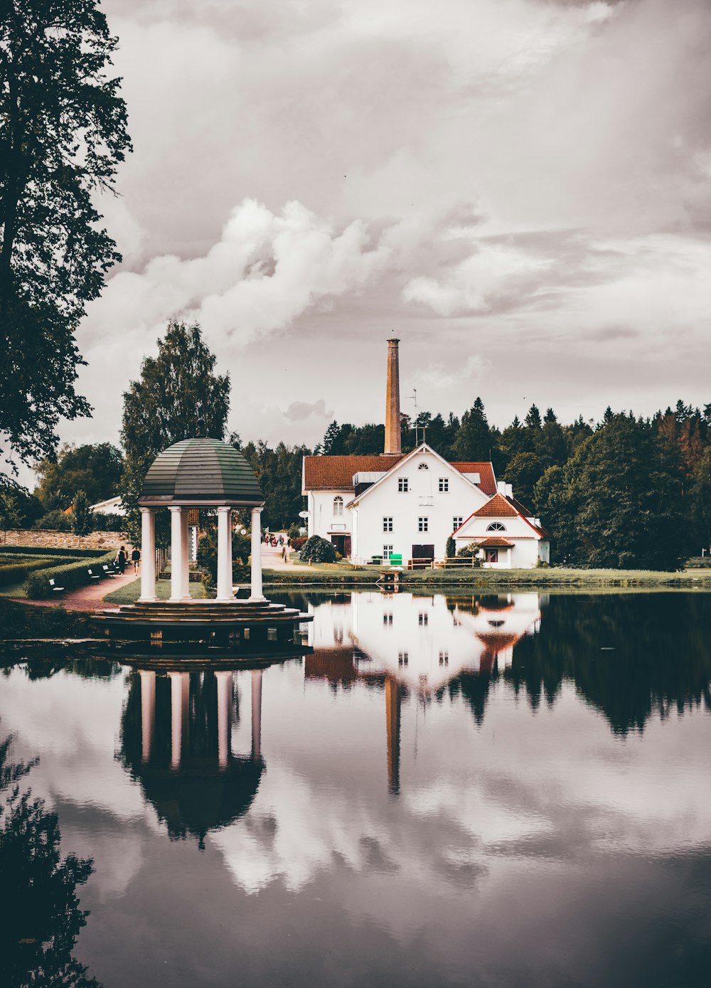 Casa branca e marrom perto do lago e das árvores