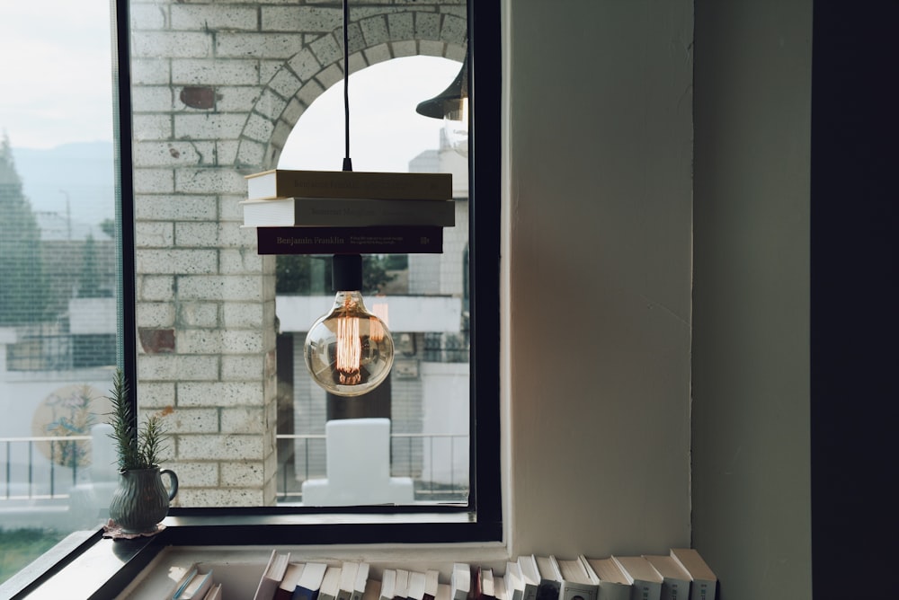 Lámpara colgante de vidrio transparente dentro de la habitación de concreto blanco y marrón durante el día