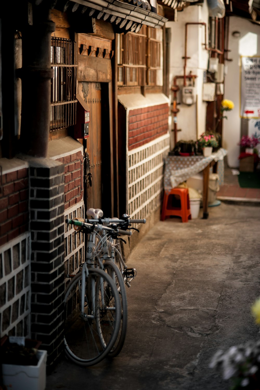 two white bicycles parked beside concrete wall