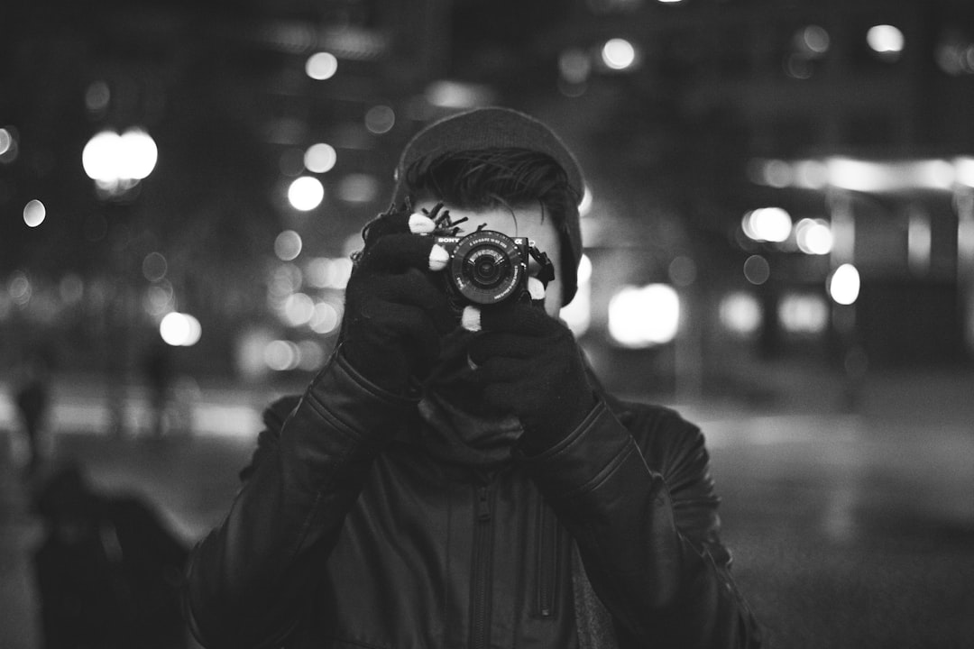 grayscale photo of a man taking a photo