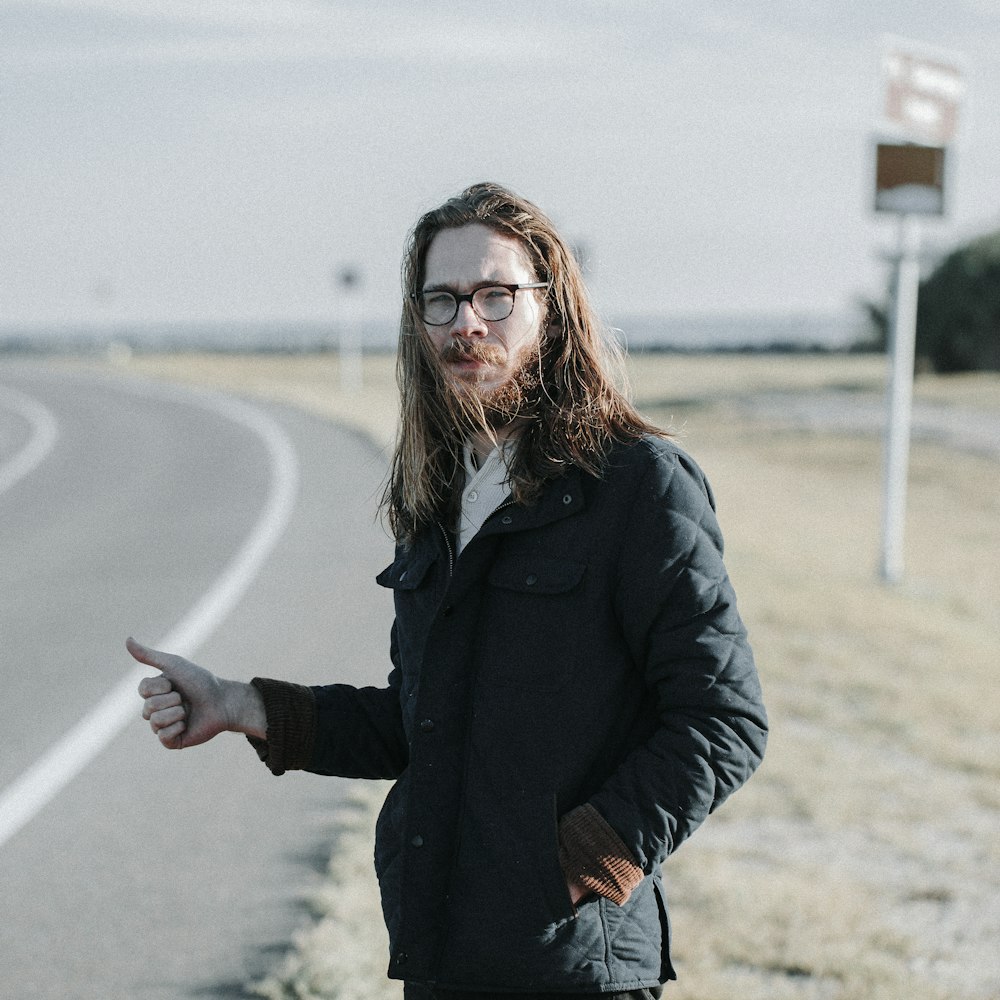 man standing near road during daytime