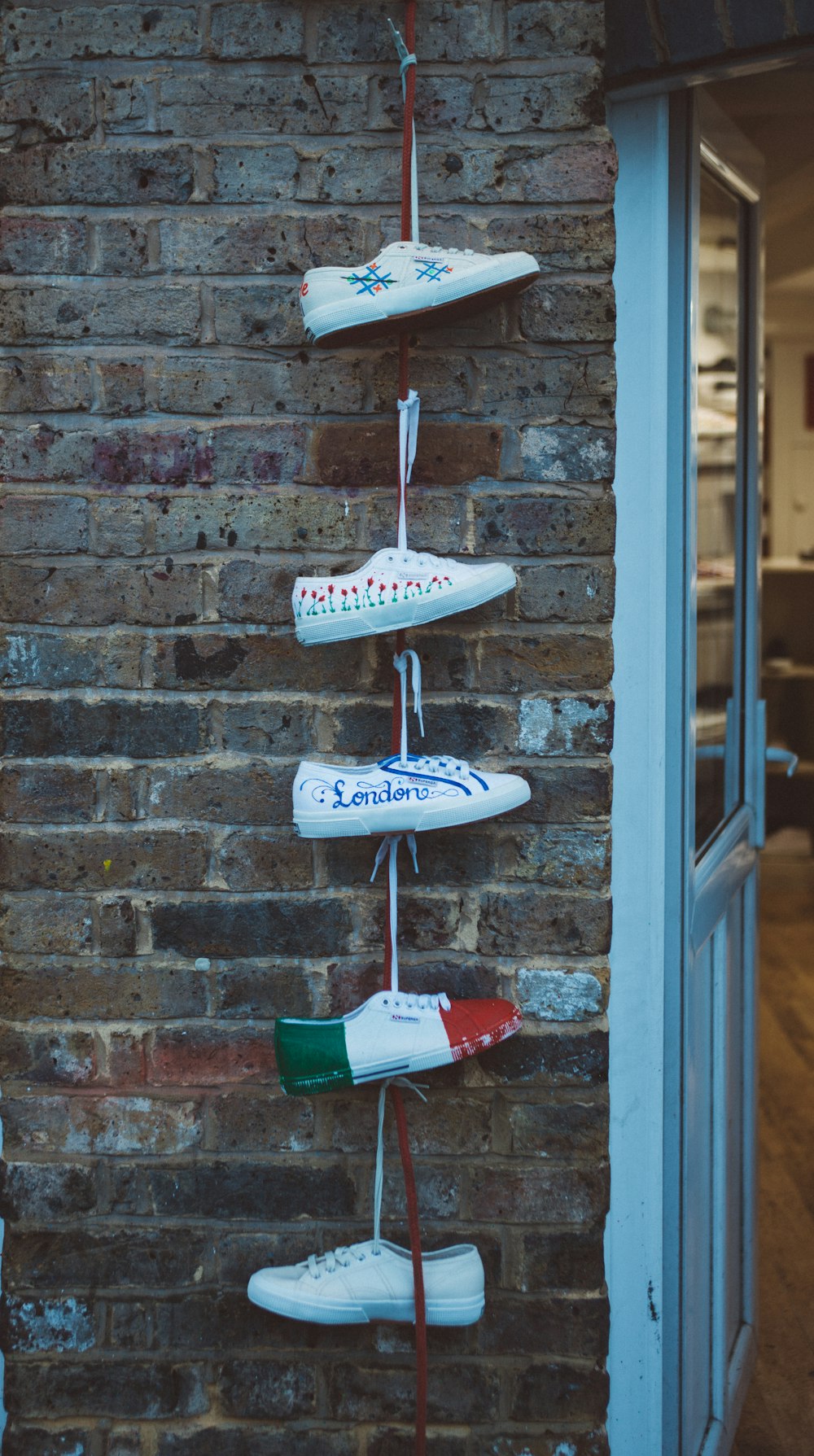 five white sneakers hanged near white door