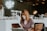woman sitting on brown wooden chair while using silver laptop computer in room