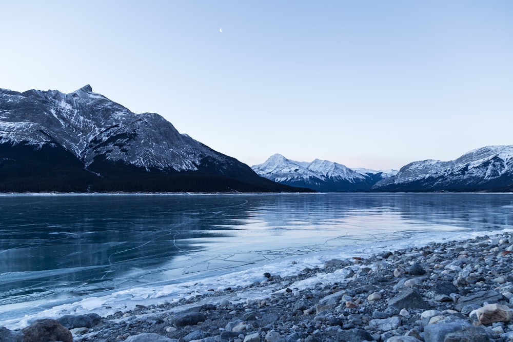 body of water surrounded with snowy mountain