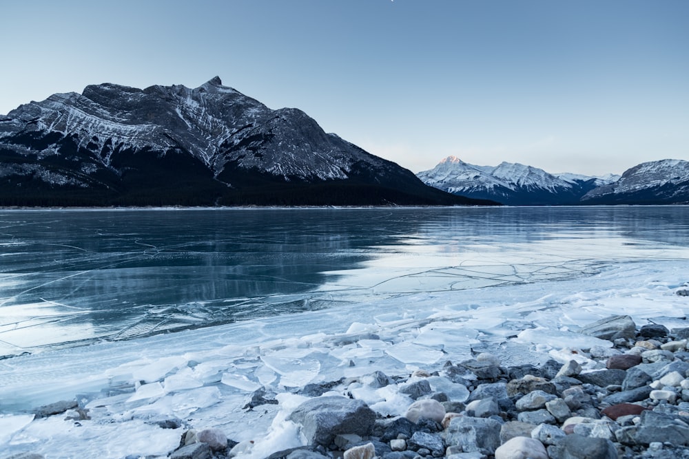 greyscale photography of body of water and mountain