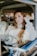 woman sitting inside car leaning on car door