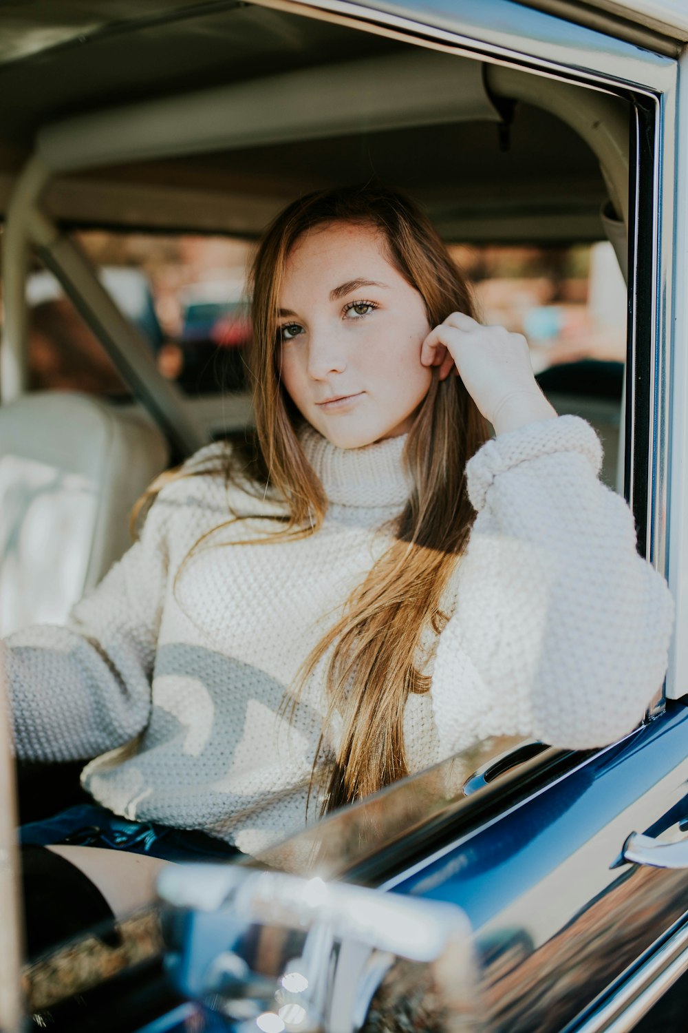 woman sitting inside car leaning on car door