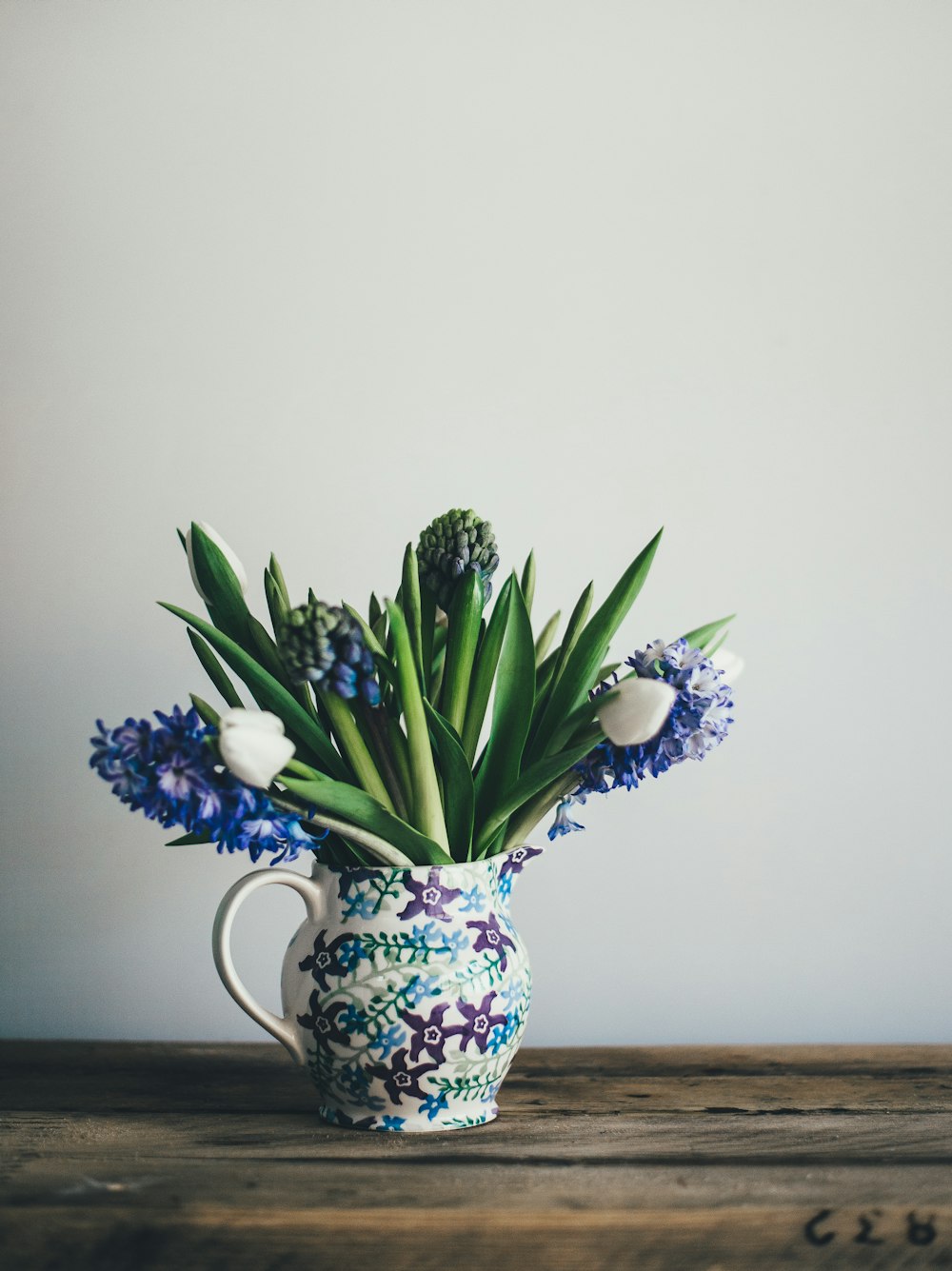 flowers on white floral vase on table